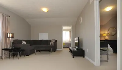a living room with a couch and a tv at Boardwalk Homes - Executive Guest Rooms & Townhomes in Kitchener