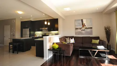 a living room and kitchen with a couch and a table at Boardwalk Homes - Vacation Homes & Executive Suites in Kitchener