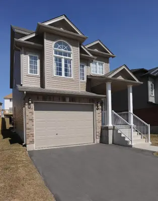 a large house with a garage door in front of it at Boardwalk Homes - Vacation Homes & Executive Suites in Kitchener
