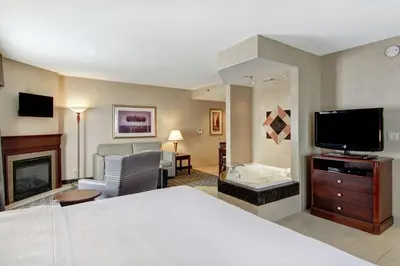 a hotel room with a bed and a television at Homewood Suites by Hilton Toronto Oakville in Oakville