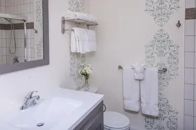 a white bathroom with a toilet and a sink at Avery House B&B in Stratford