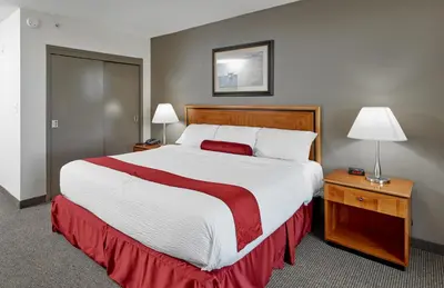 a large bed in a hotel room with two lamps at The Falls Hotel & Inn in Niagara Falls