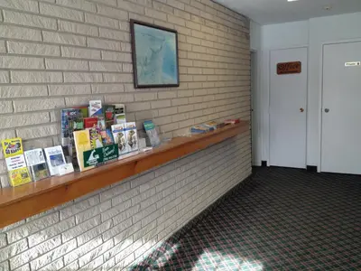 a book shelf on a brick wall with books on it at Milestone Motel in Collingwood