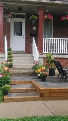 a house with a porch with stairs and flowers at Village at York U in Toronto