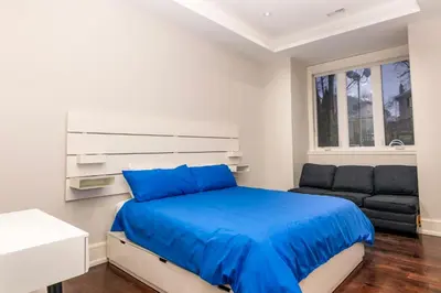 a bedroom with a bed and a couch at Hillcrest Modern House in Toronto