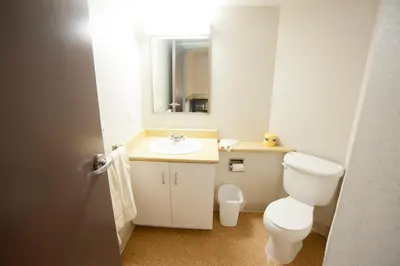 a bathroom with a toilet and a sink and a mirror at Residence & Conference Centre- Barrie in Barrie