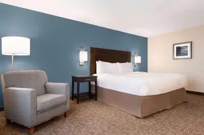 a hotel room with a bed and a chair at Wyndham Garden Niagara Falls Fallsview in Niagara Falls