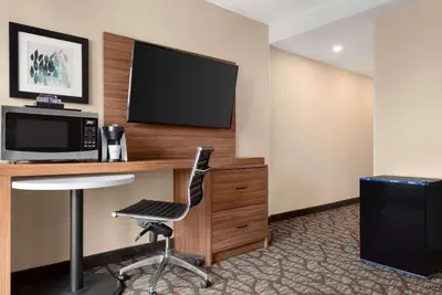 a hotel room with a desk with a television and a chair at Wyndham Garden Niagara Falls Fallsview in Niagara Falls