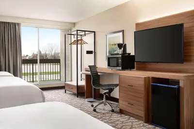 a hotel room with a desk with a television and a bed at Wyndham Garden Niagara Falls Fallsview in Niagara Falls