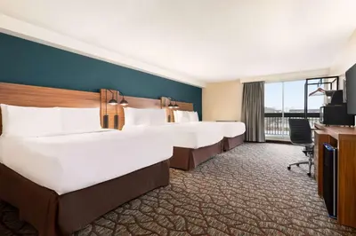 a hotel room with four beds and a television at Wyndham Garden Niagara Falls Fallsview in Niagara Falls