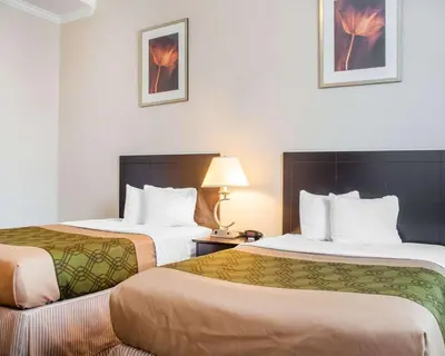 a hotel room with two beds and a lamp at Woodstock Inn and Suites in Woodstock