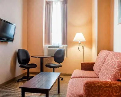 a living room with a couch and a table and a window at Woodstock Inn and Suites in Woodstock