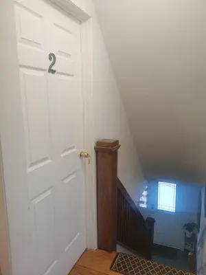 a white door in a room with a staircase at Cozy House B&B in Niagara Falls