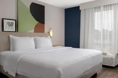 a bedroom with a large white bed and a window at Spark By Hilton Woodstock in Woodstock