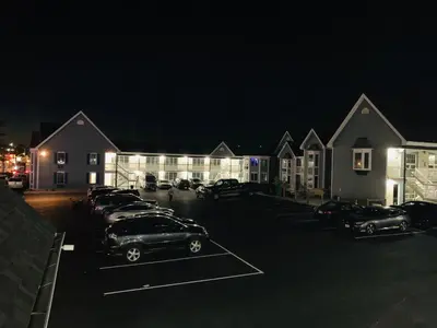 a group of cars parked in a parking lot at night at Falls Lodge & Suites in Niagara Falls