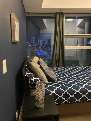 a bedroom with a bed with a view of a city at Stylish Condos Toronto in Toronto