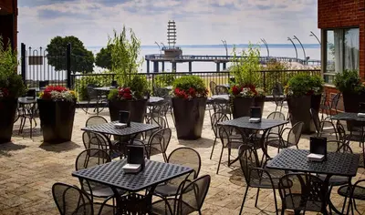 an outdoor patio with tables and chairs with flowers at Waterfront Hotel Downtown Burlington in Burlington