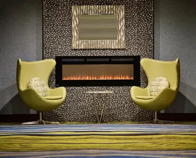 two yellow chairs in front of a fireplace at Waterfront Hotel Downtown Burlington in Burlington