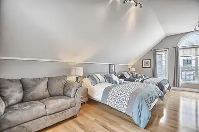 a living room with two beds and a couch at 6 Bedroom Executive Cottage near Innisfil Beach Park in Innisfil