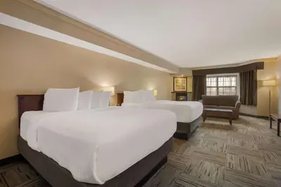 a hotel room with two beds and a chair at Best Western Brantford Hotel and Conference Centre in Brantford