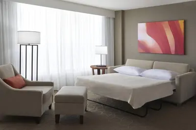 a hotel room with a bed and a chair at Delta Hotels by Marriott Toronto Airport & Conference Centre in Toronto