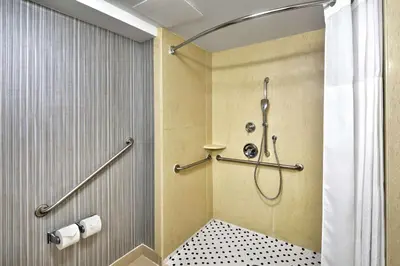 a bathroom with a shower with a shower curtain at Hampton Inn & Suites by Hilton Toronto Airport in Mississauga