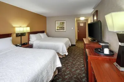 a hotel room with two beds and a flat screen tv at Hampton Inn & Suites by Hilton Toronto Airport in Mississauga