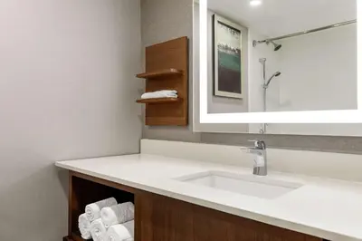 a bathroom with a sink and a mirror and towels at Hilton Garden Inn Kitchener/Cambridge in Cambridge