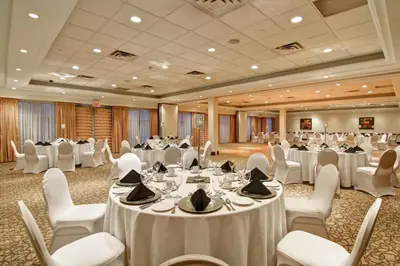 a banquet hall with white tables and white chairs at Hilton Garden Inn Toronto/Burlington in Burlington