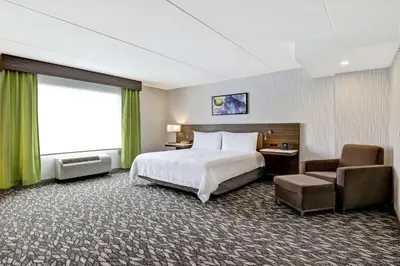 a hotel room with a bed and a chair at Hilton Garden Inn Toronto/Ajax in Ajax