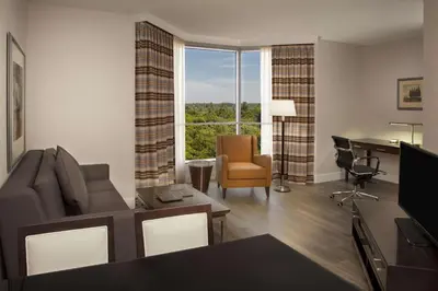 a living room with a couch and a desk and a window at Hilton Suites Toronto-Markham Conference Centre & Spa in Markham