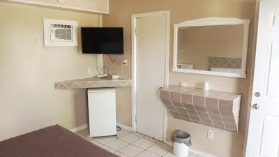 a small kitchen with a tv and a mirror at Pleasant Stay Motel in Ancaster