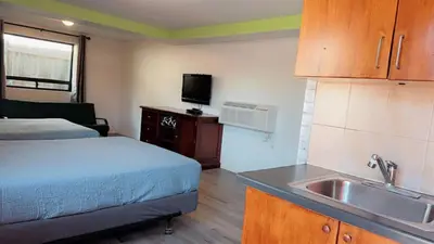 a kitchen with a bed and a sink in a room at Crestwood Motel in Burlington