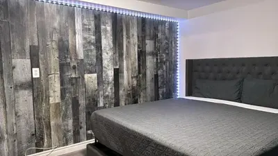 a bedroom with a bed and a wooden wall at Crestwood Motel in Burlington