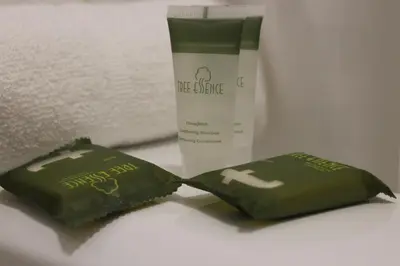 two green packets of face cleanser next to a bottle of cream at Super 7 Motel London in London