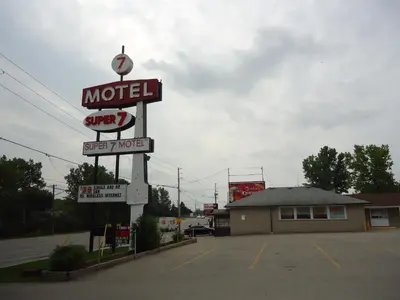 a motel sign on the side of a parking lot at Super 7 Motel London in London