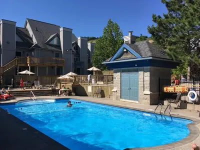 a person swimming in a large blue swimming pool at Blue Mountain Getaway at North Creek Resort King Bed in Blue Mountains
