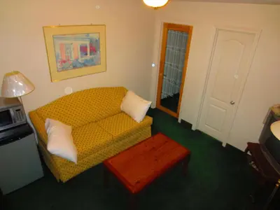 a living room with a yellow couch and a table at Canadiana Motel in Hanover