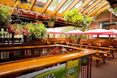 a restaurant with wooden tables and benches and pink umbrellas at Madison Manor Boutique Hotel in Toronto