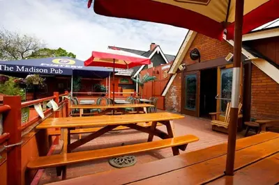 a patio with wooden tables and umbrellas on a building at Madison Manor Boutique Hotel in Toronto