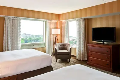 a hotel room with a bed and a television and a chair at DoubleTree Fallsview Resort & Spa by Hilton - Niagara Falls in Niagara Falls