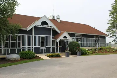 a black building with a brown roof and a driveway at Living Stone Golf Resort in Collingwood