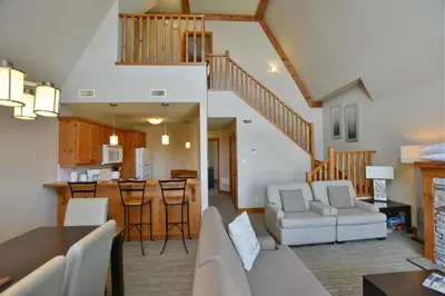 a kitchen and living room with a staircase and a living room at The Blue Escape Blue Mountain Chalet in Blue Mountains