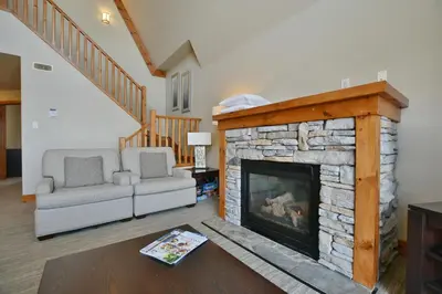 a living room with a stone fireplace at The Blue Escape Blue Mountain Chalet in Blue Mountains