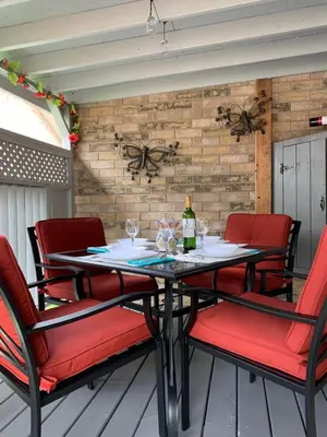a table with red chairs and a bottle of wine at Evening Shade in Fergus