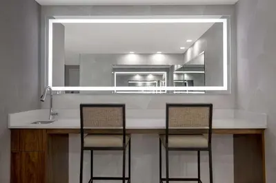 a kitchen with a counter with two chairs and a mirror at Hampton Inn by Hilton Brampton - Toronto in Brampton