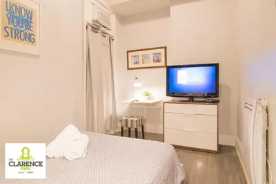 a bedroom with a tv on a dresser with a bed at The Clarence Park in Toronto