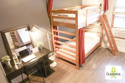 a bedroom with a desk and a bunk bed with a laptop at The Clarence Park in Toronto