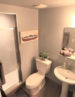 a bathroom with a toilet and a shower and a sink at The Clarence Park in Toronto
