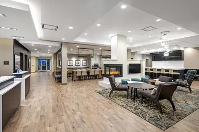 an office lobby with a fireplace and tables and chairs at Residence Inn by Marriott Toronto Mississauga West in Mississauga